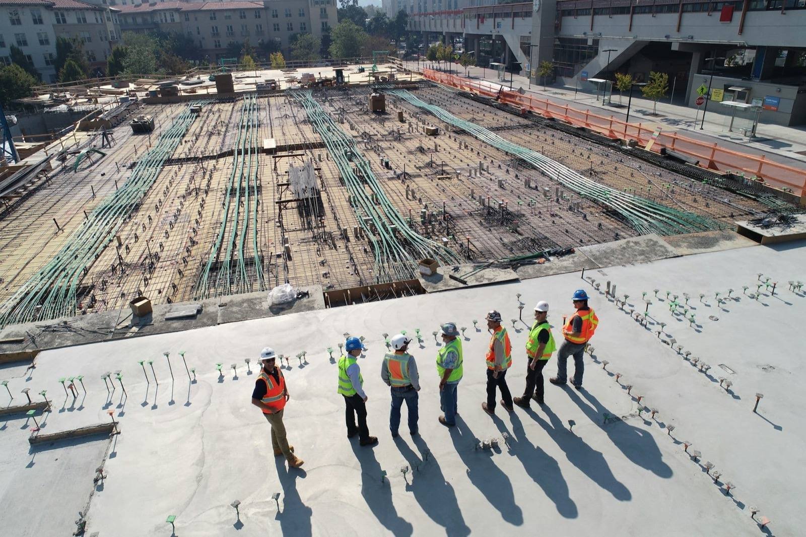 Engineers and sustainability professionals in PPE reviewing a major construction project from an overlook